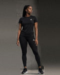 Female model wearing a black GE short-sleeve crew-neck T-shirt and matching ankle-length leggings with white logos.