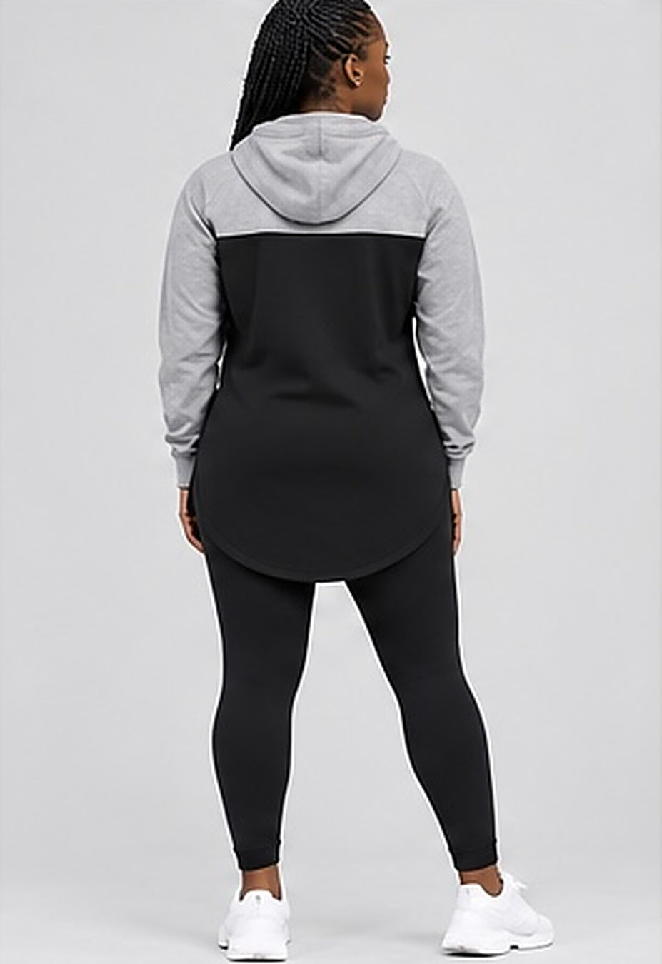 Back view of the GE grey and black elongated hoodie and black leggings showing the curved longline hem.
